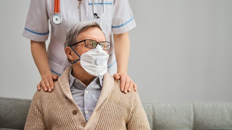 Man with a protective mask and healthcare professional